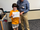 Ten-year-old new ham Reynaldo Mangual, KM7HFU, is presented with his certificate of successful completion of the amateur radio Technician exam by Maricopa Amateur Radio Club president and 4-H group leader Michael Mills, NO7S. [Photo courtesy Maricopa Amateur Radio Club]